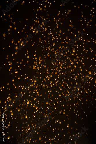 Thai fire lanterns flying in the night sky during the annual Yi Peng festival of light in Chiang Mai Thailand