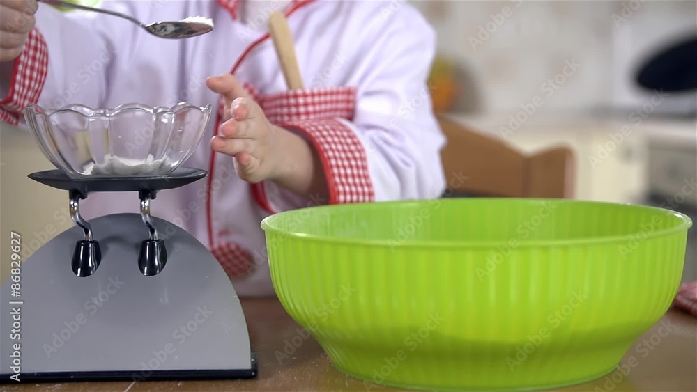 Young cook adding bicarbonate of soda in to dough Young cook adding bicarbonate of soda in to dough