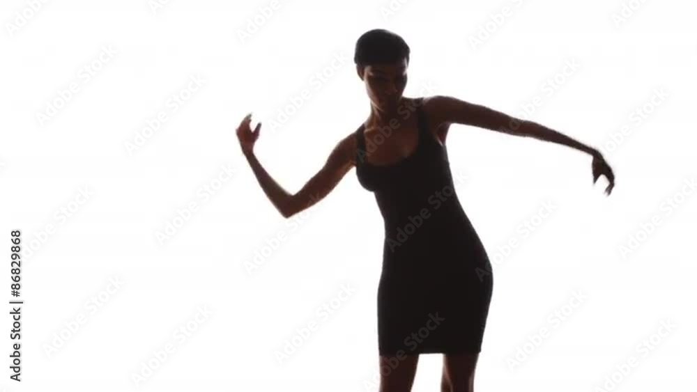 Woman in black dress smiling and dancing on white background in slow motion Woman in black dress smiling and dancing on white background in slow motion