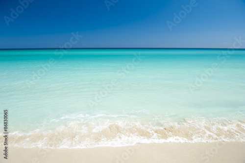 Shore of classic turquoise Caribbean Sea dream beach under bright blue sky in Varadero, Cuba