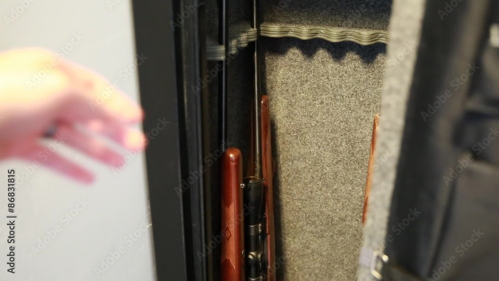 a man removes a gun from the safe a man removes a gun from the safe