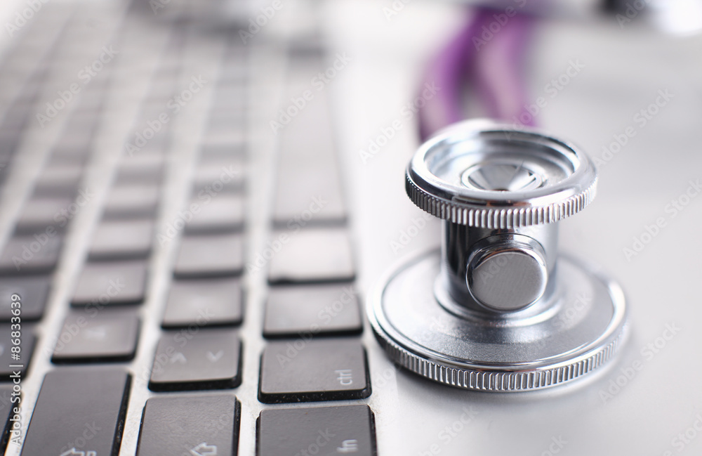 Violet stethoscope on a laptop computer Violet stethoscope on a laptop computer