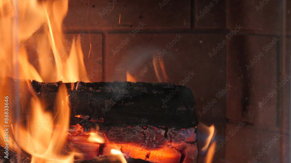 A hot fire in a living room fireplace