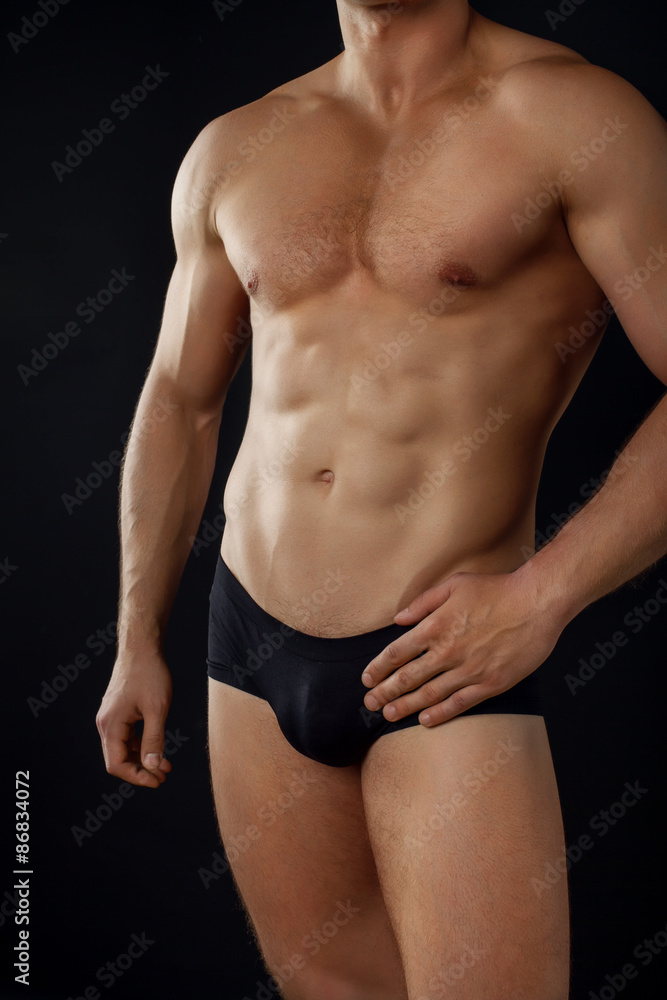 Fit young sportsman is showing his perfect body Fit young sportsman is showing his perfect body