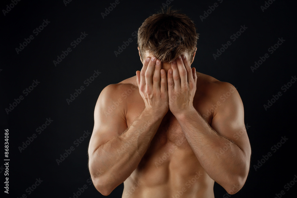 Attractive young male athlete is expressing shame