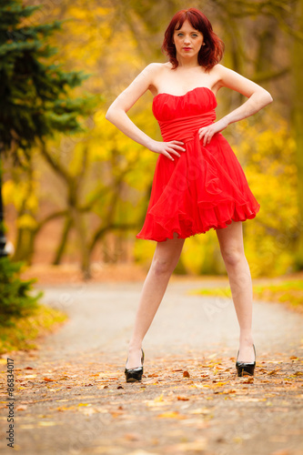 Fototapeta Naklejka Na Ścianę i Meble -  Fashion woman red dress relaxing walking in park