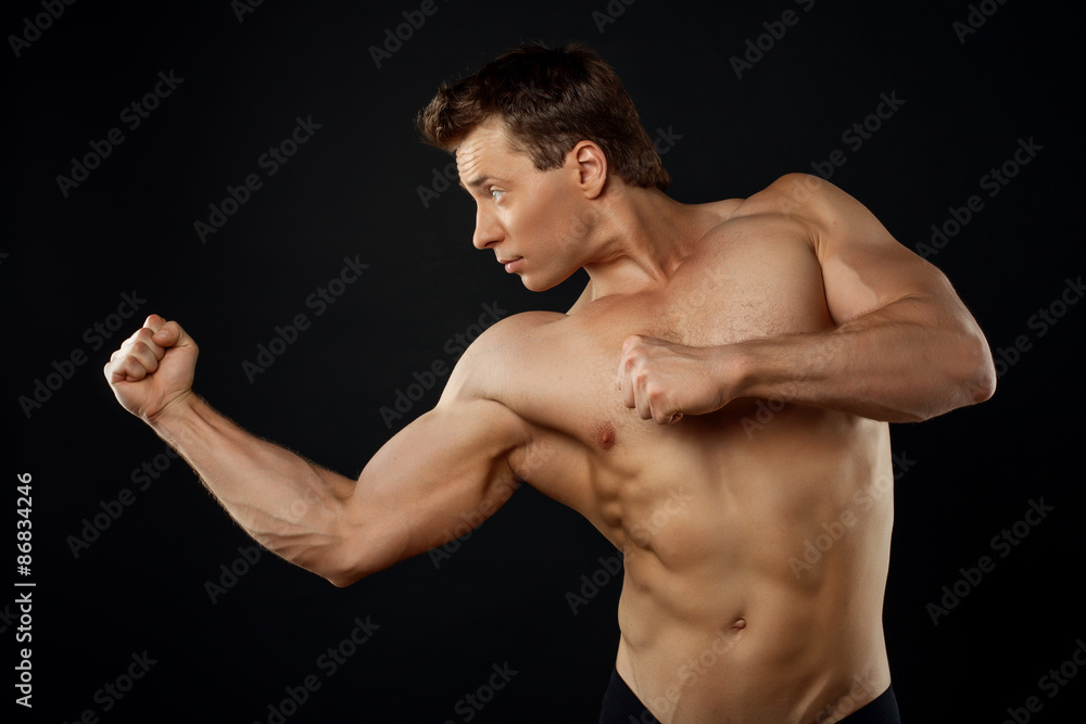 Attractive young sportsman is fighting with someone