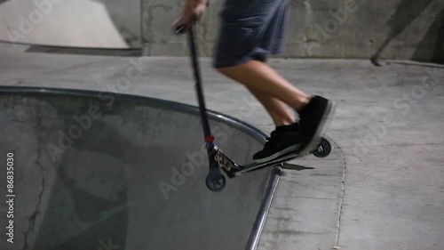 teens riding their razors at skate park at night photo