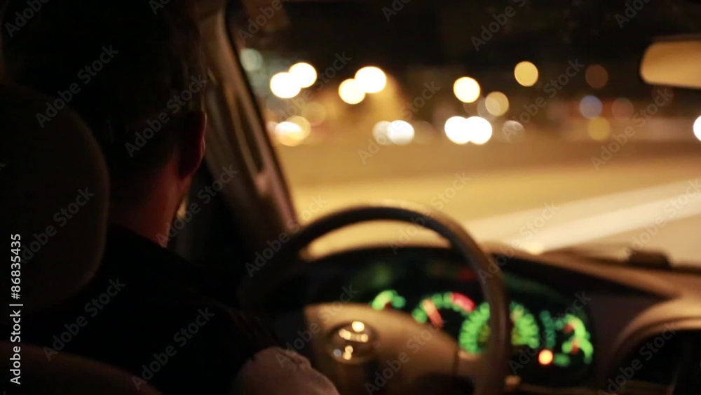 a man driving at night down a highway a man driving at night down a highway