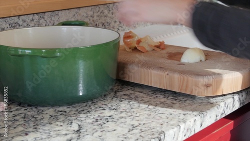 Mother dices an onion on a cutting board photo