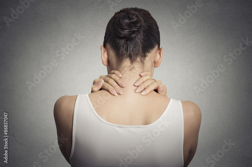 tired female massaging her painful neck photo