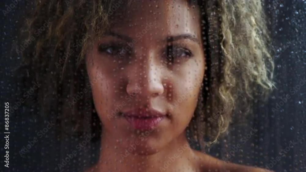 Portrait of African woman looking through foggy glass Portrait of African woman looking through foggy glass