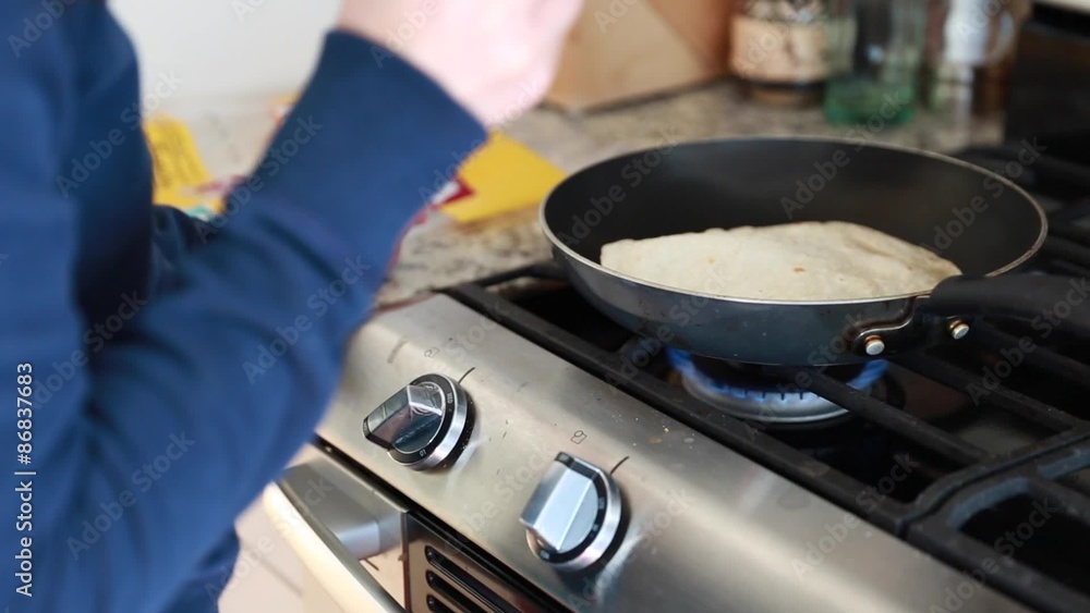 a woman cooking fresh tortilla in a pan a woman cooking fresh tortilla in a pan