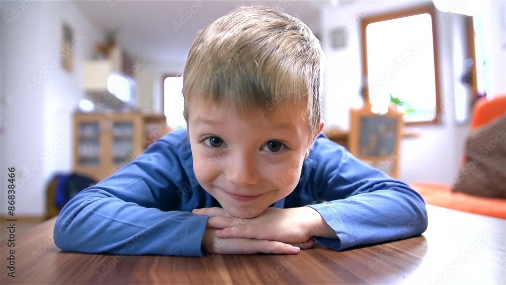Cute Child Lie On Table Smiling In Camera Cute Child Lie On Table Smiling In Camera