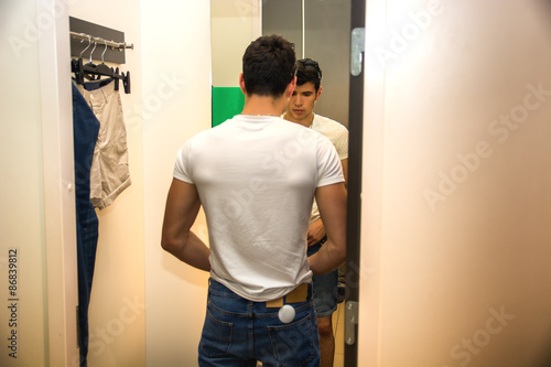 Fotografie Young Man Trying on Clothes in Clothing Store