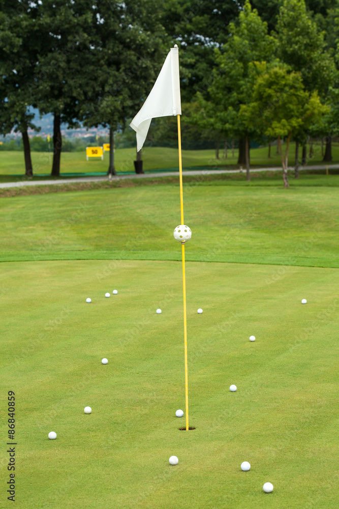 Obraz premium White flag on a golf course, focus on the flag