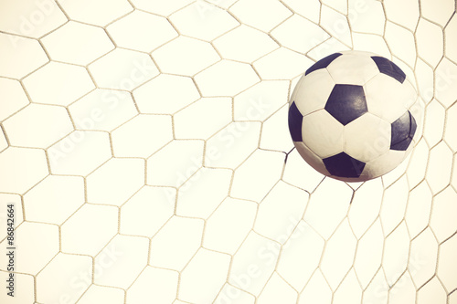 soccer ball in goal on white background vintage color © FAMILY STOCK