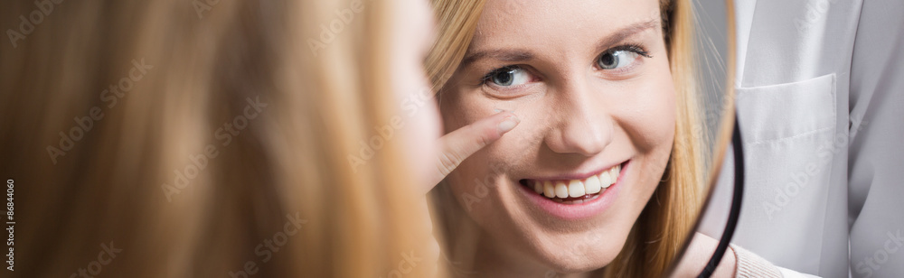 Obraz premium Female putting in contact lens