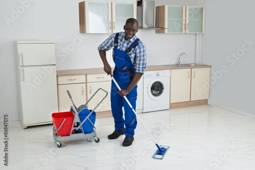 African Male Worker Cleaning Floor With Mop