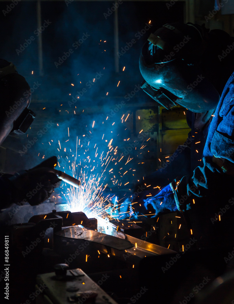 MIG welder uses torch to make sparks during manufacture of metal equipment. MIG welder uses torch to make sparks during manufacture of metal equipment.