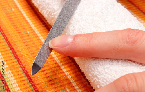 Woman polishing fingernails with nail file