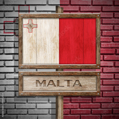 Malta flag wooden sign with brickwall background