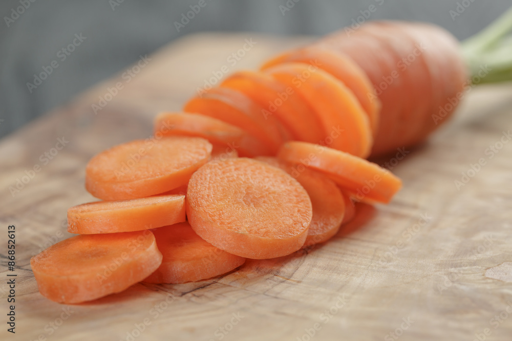 sliced organic carrot on olive wood cutting board sliced organic carrot on olive wood cutting board