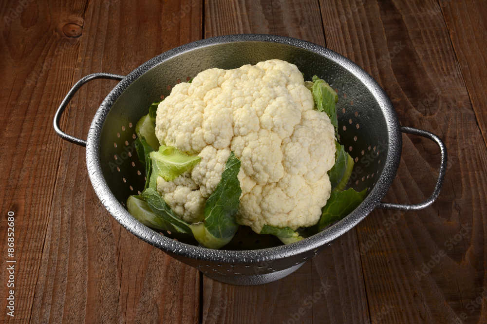 Cauliflower in Colander on Wood Table Cauliflower in Colander on Wood Table