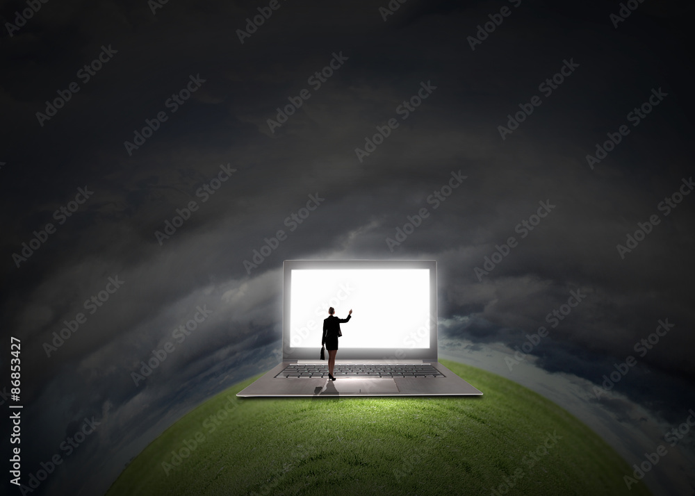 Woman standing on big laptop