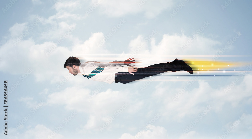 Naklejka premium Happy business man flying fast on the sky between clouds