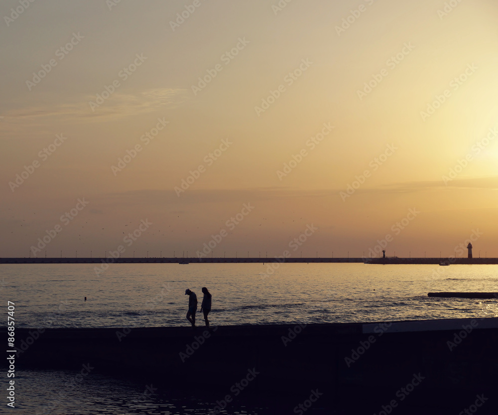 Couple walking at the beach in the evening