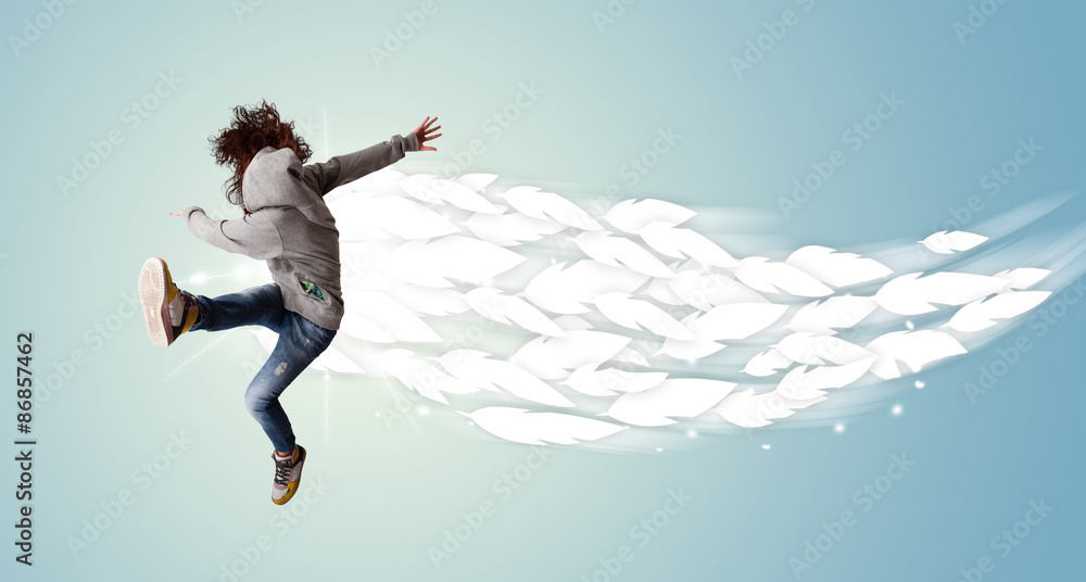 Healthy young woman jumping with feathers around her