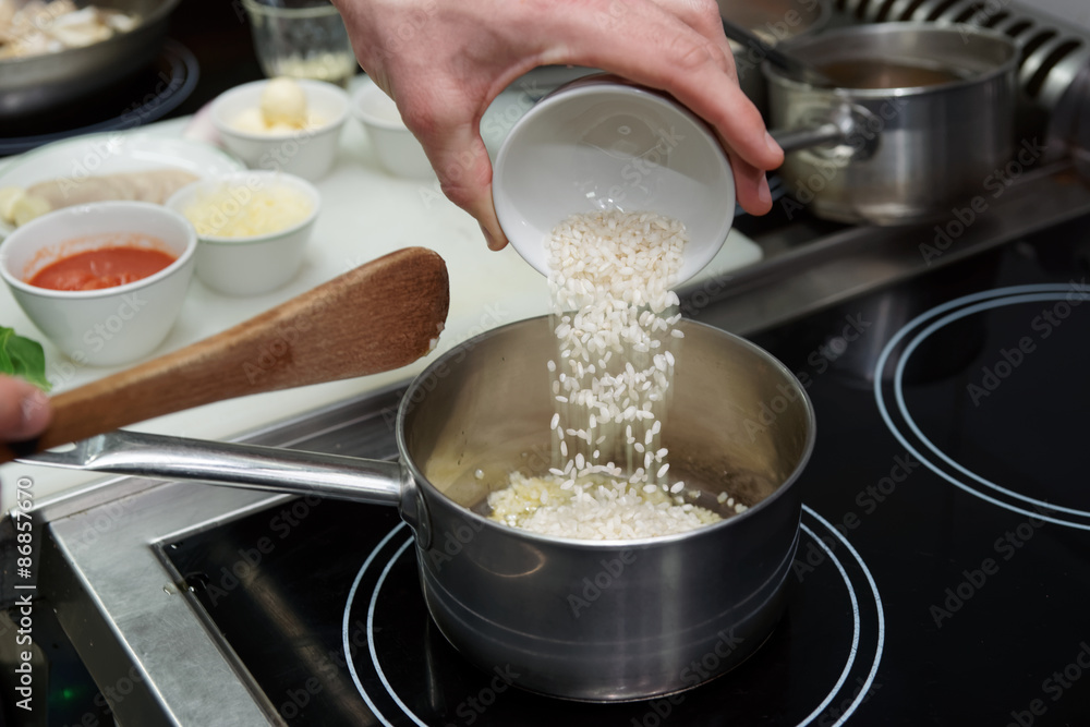 Chef is pouring rice in stewpan Chef is pouring rice in stewpan