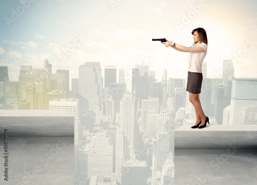 Businesswoman standing on the edge of rooftop © ra2 studio