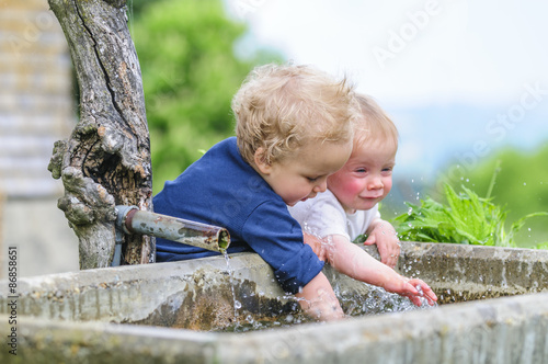 Zwei kleine Jungs spielen am Brunnen