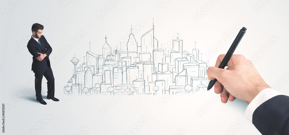 Businessman looking at hand drawn city on wall Businessman looking at hand drawn city on wall