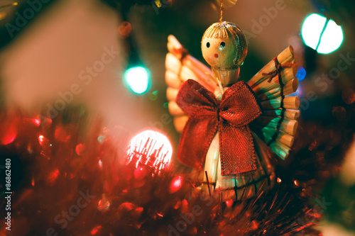 Cute wooden Christmas angel hanging in tree