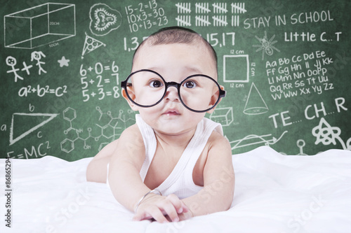 Obraz na plátně Funny baby with glasses and a doodles background