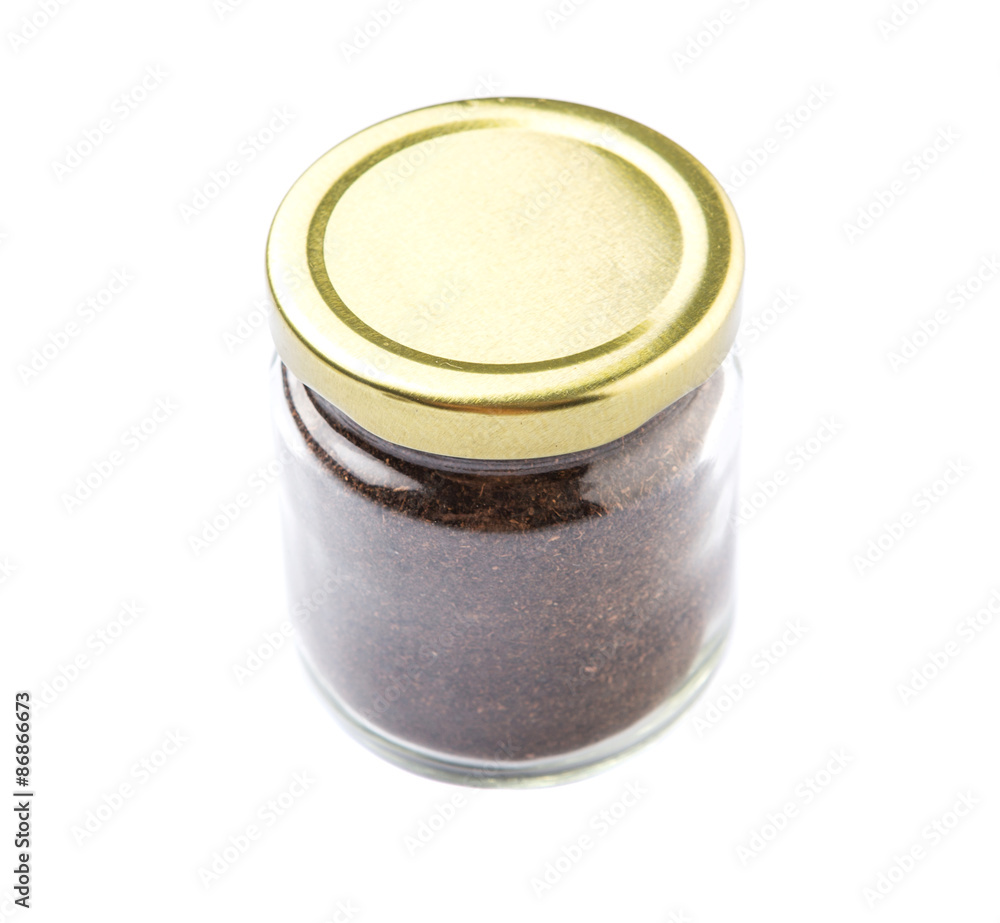 Dried processed tea leaves in a mason jar over white background Dried processed tea leaves in a mason jar over white background
