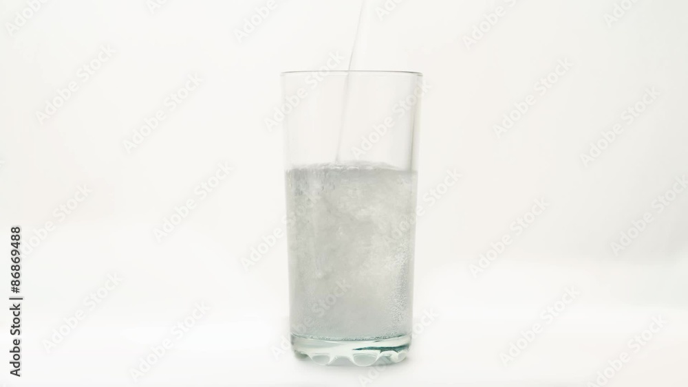 Carbonated water is poured into a glass on a white background Carbonated water is poured into a glass on a white background