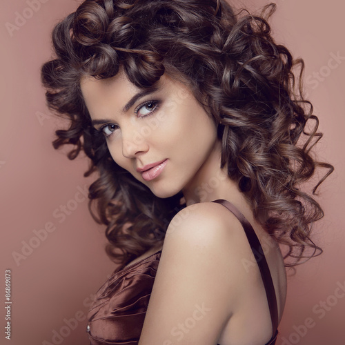 Wavy hair. Attractive smiling girl with makeup. Curly hairstyle.