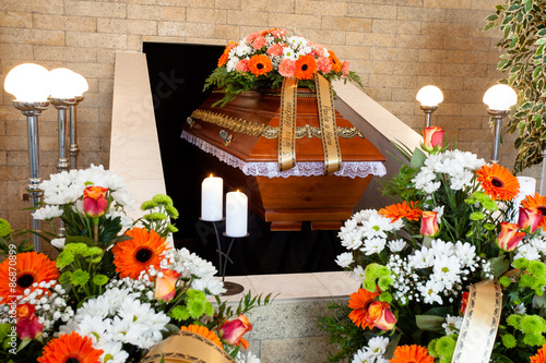 Funeral hall with wooden coffin and flower decoration, prepared for burial ceremony
