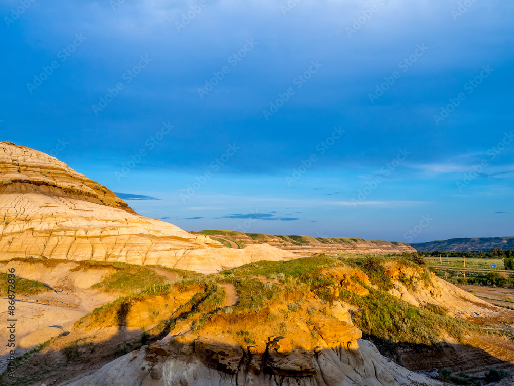 Badlands bathed in the warm light of a summer sunset near drumheller in Alberta Canada.