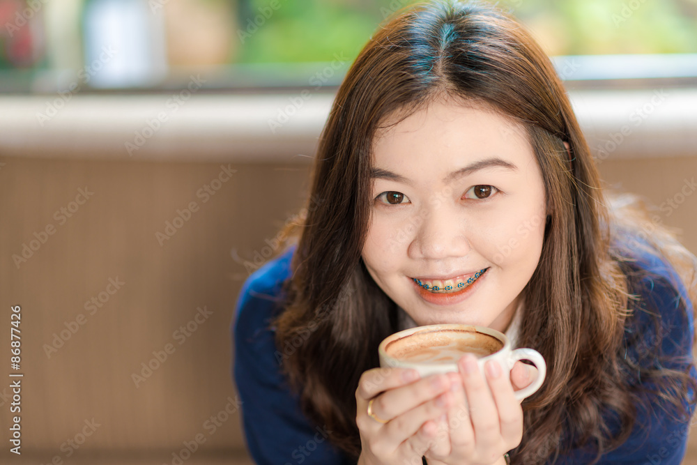 Happy asian smiling female student drinking coffee Happy asian smiling female student drinking coffee