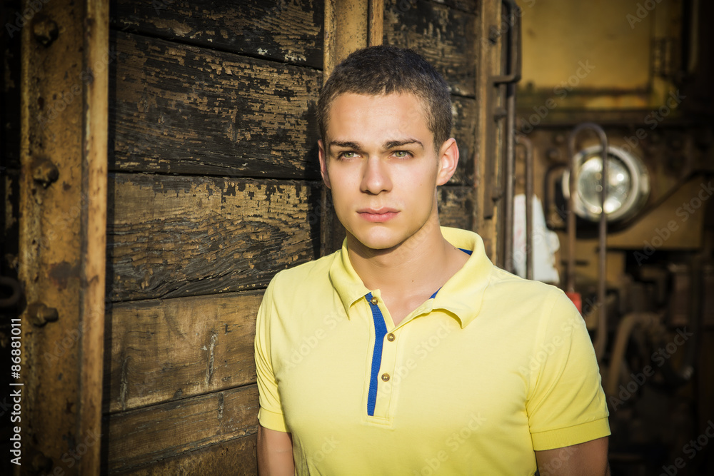 Handsome young man next to wood planks wall Handsome young man next to wood planks wall