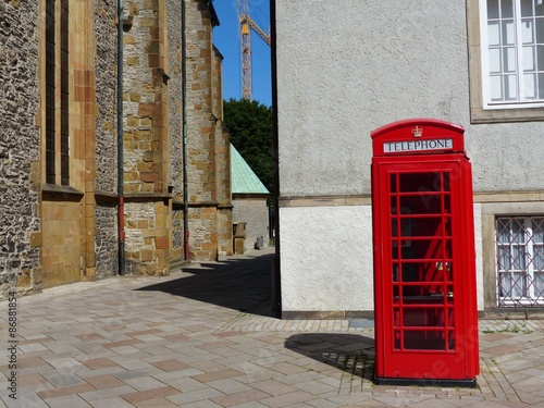 Rote englische Telefonzelle bei Sonnenschein an der Altstädter Nicolaikirche  in der Innenstadt von Bielefeld im Teutoburger Wald in Ostwestfalen-Lippe photo