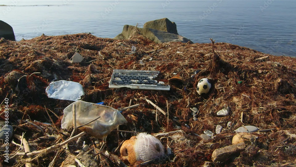 Broken computer keyboard among waste and garbage brought to shore by sea waves Broken computer keyboard among waste and garbage brought to shore by sea waves