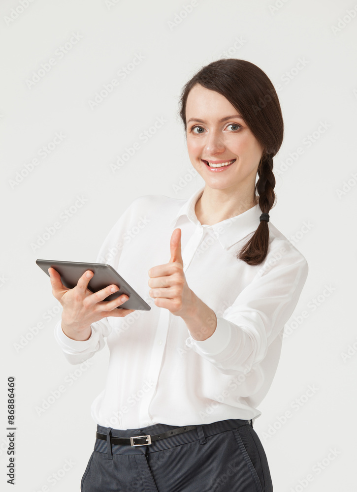 Smiling young businesswoman holding a pad and showing thumb up s Smiling young businesswoman holding a pad and showing thumb up s
