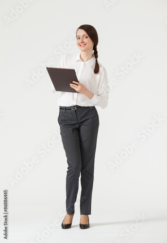 Smiling young businesswoman holding clipboard