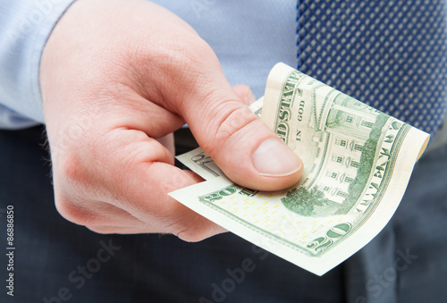 Unrecognizable businessman holding twenty dollars